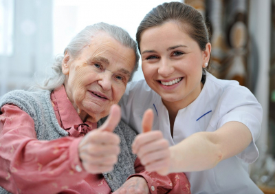 senior woman and female caregiver are showing thumbs up