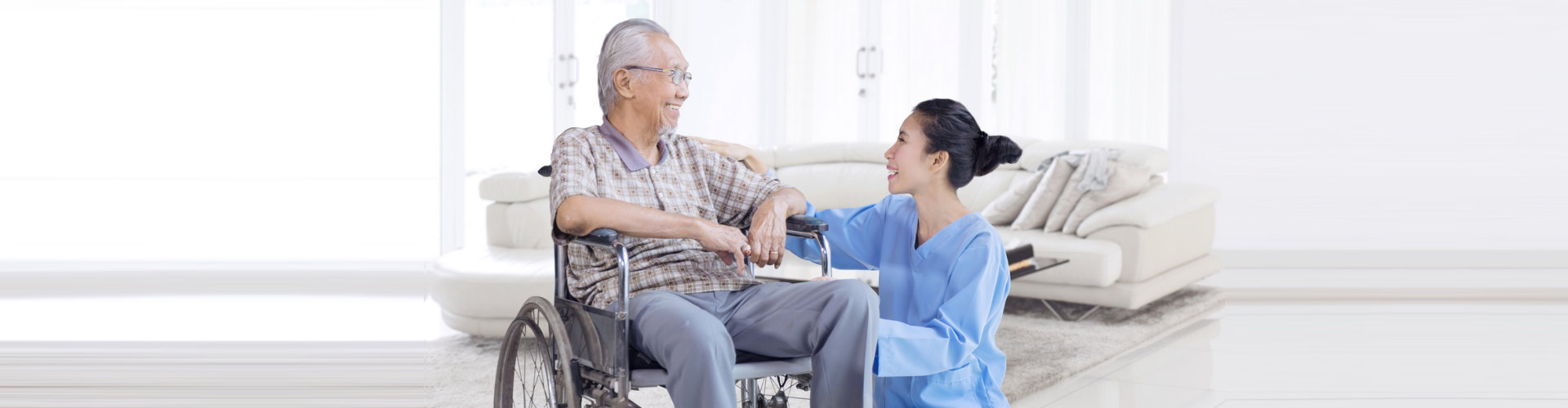 caregiver and senior man with wheelchair are smiling