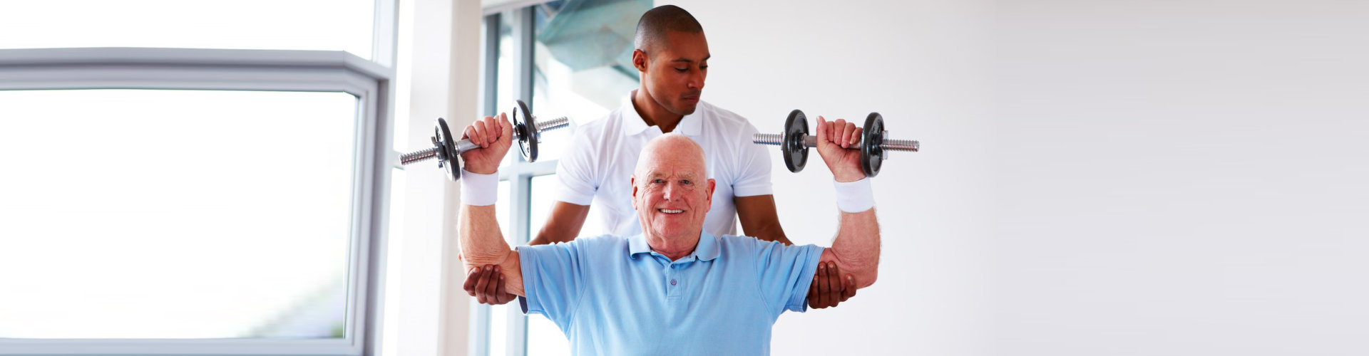 male caregiver assisting senior man doing an exercise