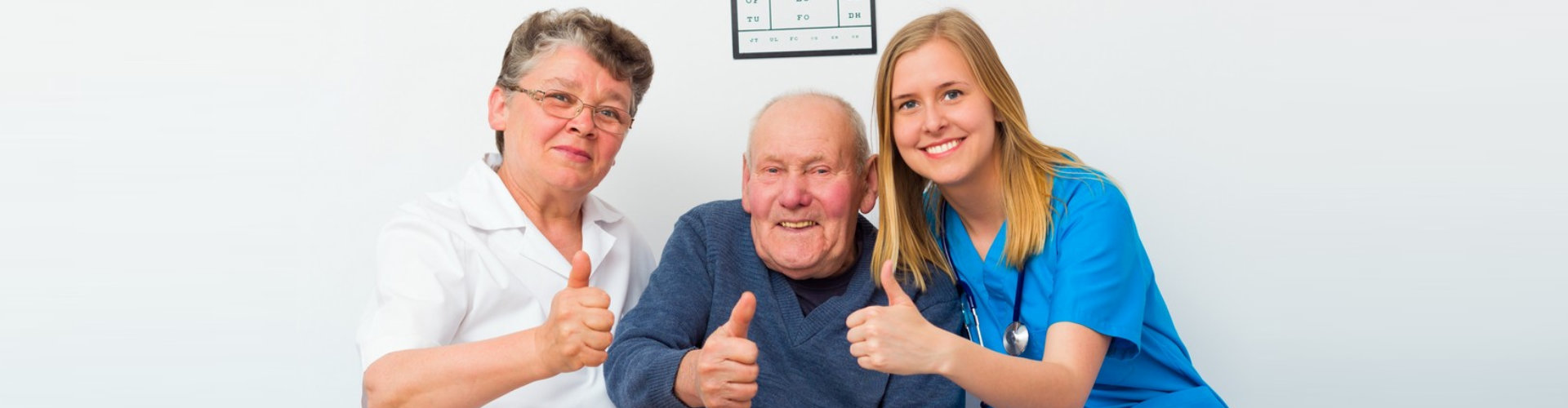senior couple and caregiver doing a thumbs up